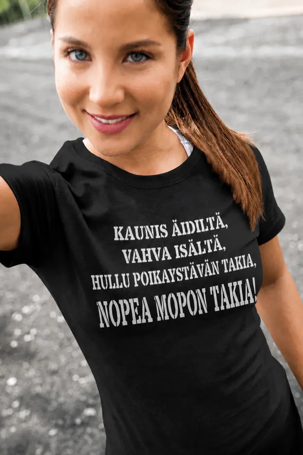 Nainen mustassa T-paidassa, jossa lukee kaunis äidiltä, vahva isältä, hullu poikaystävän takia, nopea mopon takia