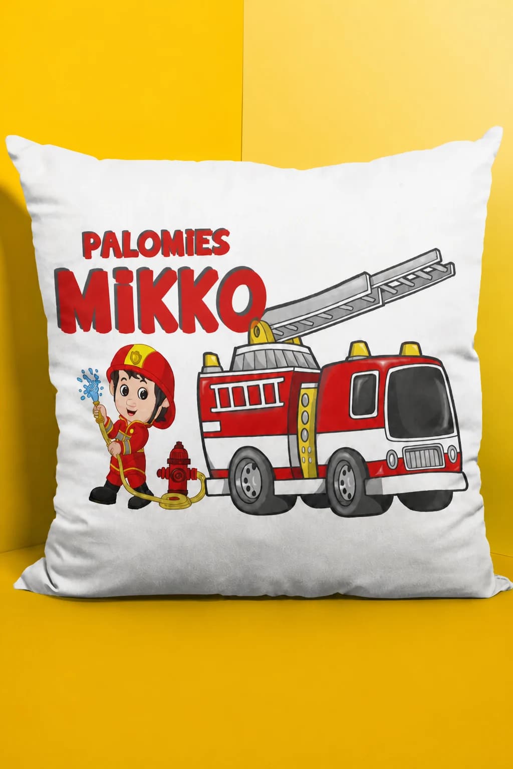Valkoinen nimikoitava koristetyyny, jossa pieni palomies, paloauto ja teksti PALOMIES MIKKO