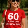 Hauska t-paita 60 ja yhä seksikkäämpi, jossa teksti 60 JA AINA VAIN SEKSIKKÄÄMPI.