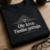 Musta t-paita, jossa pieni silmäikoni ja teksti Ole kiva. Tiedän juttuja.