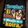 Bright, playful dog-lover T-shirt with a happy cartoon dog high-fiving beside the exact Finnish slogan Terapiaa? Ei kiitos. Minulla on koira., surrounded by small paw prints.